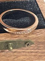 Ring lying in box showing wave design and gemstones