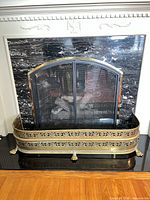 Full view of brass fireplace fender in front of fireplace