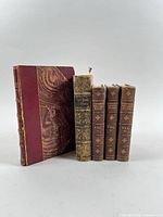 Five books standing: three matching Cowper volumes, Fielding volume with detached spine and marbled cover