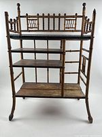 Full front view of bamboo étagère showing three shelves and stick-and-ball gallery