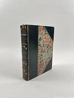 Front angled view showing half-leather binding, marbled board and spine gilt