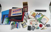 Overall lot layout with notebooks, binders, file folder pack, stapler, calculators, markers, cards, frames