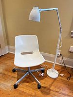 white swivel chair and floor lamp overview