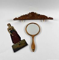Group shot: carved wood fragment, hand mirror, painted copper figure