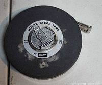 Front view of Lufkin white steel tape measure showing label and case wear