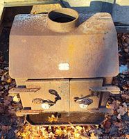 Top view of cast iron stove showing flue collar, rust, and maker plate