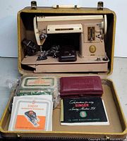 Singer 301 machine in open case with accessories and manuals displayed
