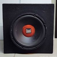Front view of subwoofer showing Dual logo and enclosure