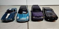 Front view of four die-cast cars in lot
