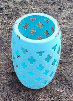 Front angle of light blue steel drum planter showing cut-outs and rust