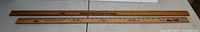 Both wooden yardsticks laid side by side showing full length and graduations
