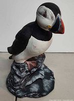 Front left view of puffin figurine showing head, beak, and rock base details