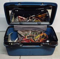 Open toolbox showing soldering iron, wires and accessories inside.