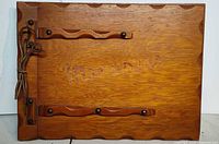 Front of wooden photo album showing leather bound spine and scalloped edges