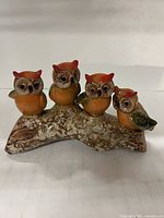 Full view of ceramic figurine with four owls on branch