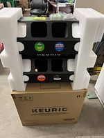 Foam-packed black Keurig merchandiser on top of original box