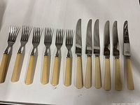 Full view of six knives and six forks lined up