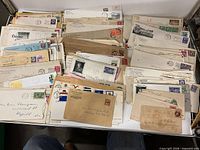 Overview of two stacks of mailed envelopes with stamps and postmarks