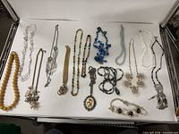 Full group of 15 necklaces laid flat on white background