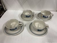 Top view showing four soup cup and saucer sets