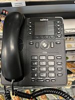 Front view of Nextiva X-835 phone with handset, display and controls