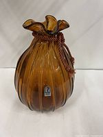 Front view of amber ribbed Pilgrim Glass vase with sticker and rope accent