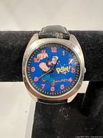 Close-up of watch dial showing Popeye graphic and numerals