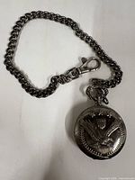 Front view showing eagle relief design and attached chain