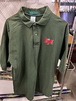 Full view of olive green polo shirt hanging