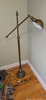 Full view of brass-tone adjustable floor lamp with cord