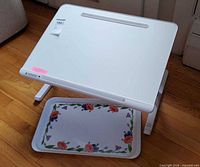 Laptop/reading desk top and floral tray visible