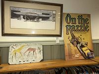 Overview showing framed boat print, giraffe slate panel, theatre poster