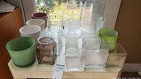 Full lot on tabletop showing variety of glass and ceramic vases