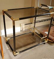 Front three-quarter view showing entire cart, frame, glass shelves and casters