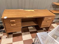 front view of desk showing drawers, shelf, damaged top