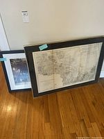 Two framed prints leaning: nautical chart and sepia photo