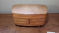 Front view of wooden jewelry box showing drawer lines and feet