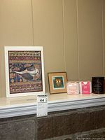 Shelf view with framed print, grow kits, candle and other frame