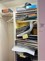 Closet shelves loaded with assorted file folders, envelopes, bubble mailers, binders