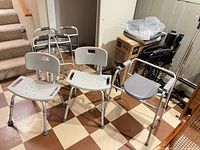 Group view showing two bath chairs, transfer bench, two standard walkers