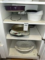 Cabinet view showing multiple serving pieces on shelves