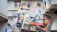 Assorted newspapers and magazines spread out showing titles