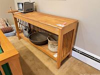 Front view of console table with slatted sides and lower shelf