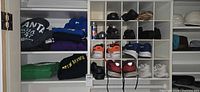 Overall view of cubbies with sweatshirts and multiple shoe pairs