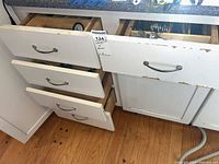 Four open kitchen drawers showing flatware and utensil storage