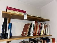 Shelf with three flashlights and multiple books