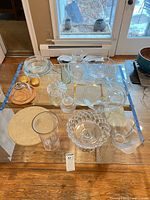 Full lot view showing variety of clear glass pieces on table