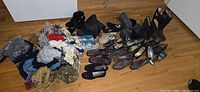 Overall lot showing shoes arranged and pile of scarves/accessories on floor
