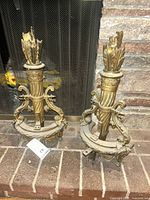 Full view of the pair of gilt andirons in front of fireplace