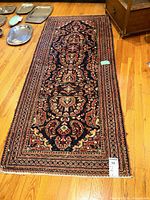 Full view of runner rug on hardwood floor showing pattern, size and condition
